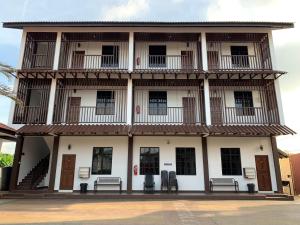 un bâtiment avec bancs devant lui dans l'établissement Wan Danisha Villa Inn, à Kota Bharu