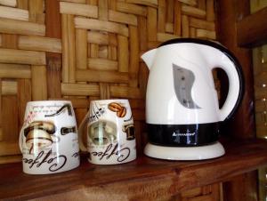 drei Kaffeetassen auf einem Holzregal in der Unterkunft Nypa Style Resort Camiguin in Mambajao