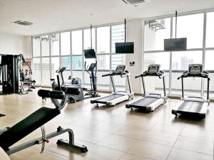 a gym with several tread machines in a large room at Delight Homestay Twin Galaxy in Johor Bahru