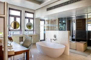 a bathroom with a large white tub and a desk at Jumeirah Al Naseem Dubai in Dubai