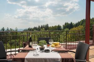 a table with a bottle of wine and glasses on a balcony at Hotel Villa Magus in Kladnitsa