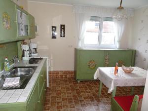 a kitchen with green cabinets and a table in it at Haus Holzheimer in Bad Kissingen