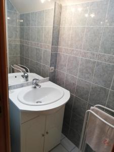 ein Bad mit einem Waschbecken und einem Spiegel in der Unterkunft La haye Georget in Feneu