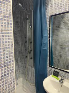 łazienka z umywalką i prysznicem z lustrem w obiekcie Hostal Alcobia w Sewilli