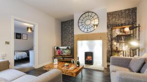 a living room with a couch and a fireplace at The Hadrian Apartment in Hexham
