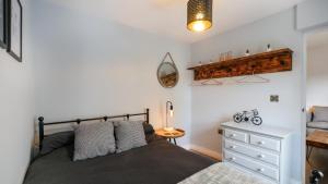 a bedroom with a bed and a dresser at The Hadrian Apartment in Hexham