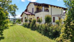 une grande maison blanche avec une cour verdoyante dans l'établissement Agriturismo Regina di fiori, à Monte Porzio
