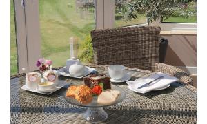 a table with a plate of food and a cake at Seven Bed and Breakfast in St. Agnes