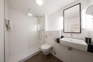 a white bathroom with a toilet and a sink at Bilderberg Hotel De Keizerskroon in Apeldoorn