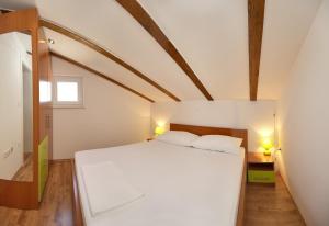 una camera da letto con un grande letto bianco e due lampade di Apartmani Gavran a Sevid Altre 35 foto
