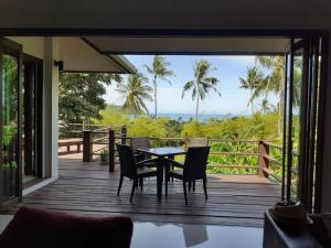 eine Holzterrasse mit einem Tisch und Stühlen darauf in der Unterkunft Sea View Villa in Thong Nai Pan Yai