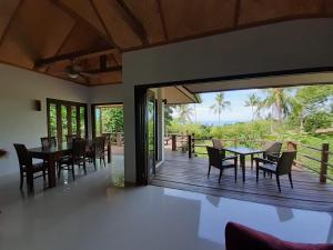 a dining room with a deck with a table and chairs at Sea View Villa in Thong Nai Pan Yai
