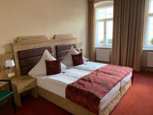 a bedroom with a large bed in a room with windows at Hotel Goldner Löwe in Stolpen