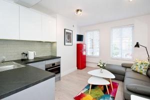 a kitchen and a living room with a red refrigerator at F4 Greek Street by City Living London in London