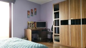 een slaapkamer met een bed en een bureau met een televisie bij Apartment Gdańsk Seaside & City Center in Gdańsk