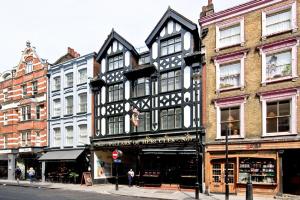 een zwart-wit gebouw in een stadsstraat bij F3 Greek Street by City Living London in Londen