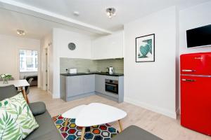 a living room with a red refrigerator and a kitchen at F2 Greek Street by City Living London in London