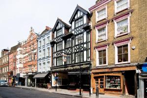 a tall building on a city street with buildings at F2 Greek Street by City Living London in London