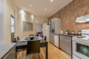 cocina con mesa de comedor y pared de ladrillo en Le Duplex VIP, en Montreal