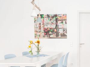 Una mesa blanca con un jarrón de flores. en Gästewohnung Jakobsgasse, en Tübingen