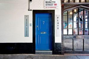 una puerta azul en el lateral de un edificio en F1 Greek Street by City Living London en Londres