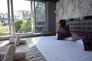 
a bedroom with a bed and a window at Hotel Hermitage Amsterdam in Amsterdam
