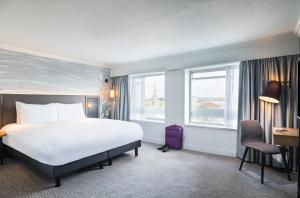 Mercure Bedford Centre Hotel في بيدفورد: غرفة فندقية بسرير ونوافذ