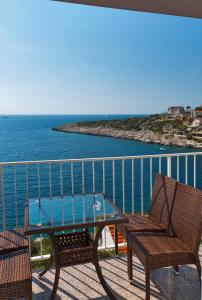 un tavolo e sedie su un balcone con vista sull'oceano di Apartmani Gavran a Sevid