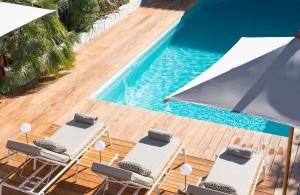 an overhead view of a pool with chairs and umbrellas at L'Anderenis Boutique Hôtel in Andernos-les-Bains