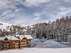 Residence Albane - maeva Home في فار: نزل في الثلج مع أشجار مغطاة بالثلج