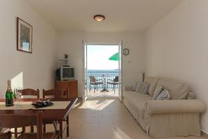 a living room with a couch and a table at Apartments Villa Alex in Podaca