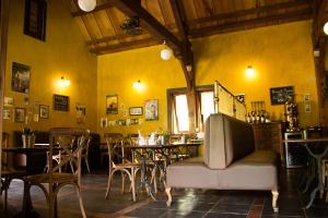 a restaurant with yellow walls and a table and chairs at Hotel Bougainviller in Kampala