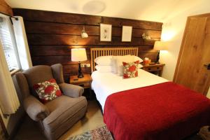 ウォルヴァーハンプトンにあるBoutique Garden Lodge @ The Larchesのベッドと椅子付きのホテルルーム