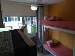 a bedroom with two bunk beds and a window at Kitnets da Tia Zeni in Arraial do Cabo