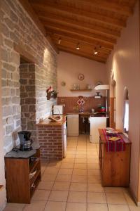 une grande cuisine avec un mur en briques dans l'établissement Château de Villeron, à Savigny-en-Revermont