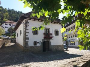 a white building with red flowers in the window at CASA GRACIANO I in Ochagavía