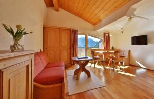 a living room with a red couch and a table at Appartements Maria Theresia in Serfaus