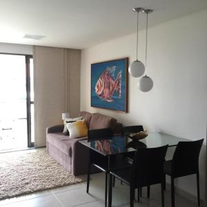un soggiorno con un divano e un tavolo di vetro di Carneiros Beach Resort a Tamandaré