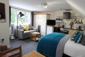 a bedroom with a bed and a kitchen and a couch at Holcombe House in Wolverhampton