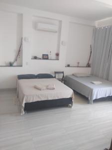 2 camas en una habitación con paredes blancas en Casa do Francês na Praia en Boa Vista