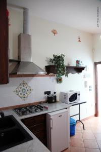 uma cozinha com um fogão e um micro-ondas em Donna Lia em Bagheria
