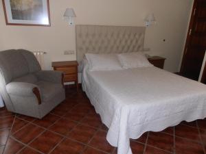 a bedroom with a bed and a chair at Hotel Cañada Real in Villalpando