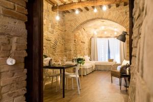 ein Esszimmer mit einem Tisch und einer Ziegelwand in der Unterkunft Il Vicolo Di Porta Pesa in Perugia
