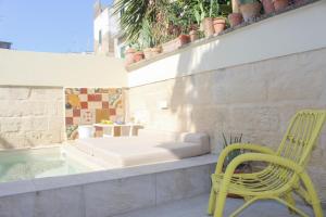 una silla amarilla sentada en un patio con bañera en Casa MaHe, en Lecce