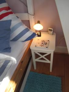 a bed with a side table with a lamp and a bed sidx sidx at Apartment am Birnbaum in Reutlingen