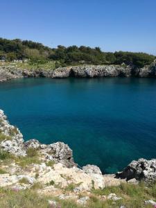 un grande bacino d'acqua con rocce in primo piano di Badisco Vacanze a Otranto