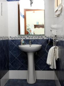 ein Bad mit einem Waschbecken und einem Spiegel in der Unterkunft Donna Lia in Bagheria