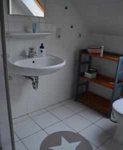 ein Badezimmer mit Waschbecken und Toilette in der Unterkunft Ferienhaus Heimathafen Neßmersiel in Neßmersiel + 31 Fotos