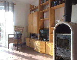 a living room with a stove and a tv at Ferienhaus Heimathafen Neßmersiel in Neßmersiel