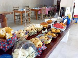 a long table with many different types of pastries at Pousada Ipoema in Ipoema